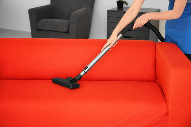 Woman cleaning couch  - Foto, afbeelding
