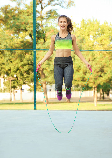 Young woman jumping rope - Фото, изображение