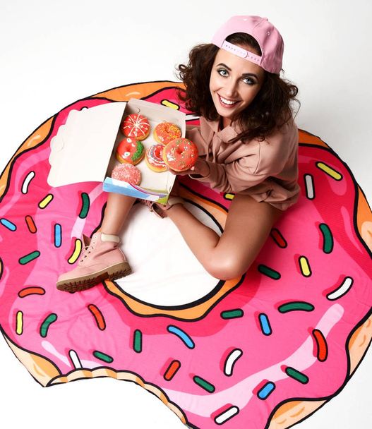cheerful woman in hot pink party hat holding box with donuts   - Foto, Bild