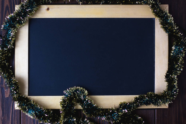 Blackboard with place for your text, surrounded by christmas garland. - Fotoğraf, Görsel
