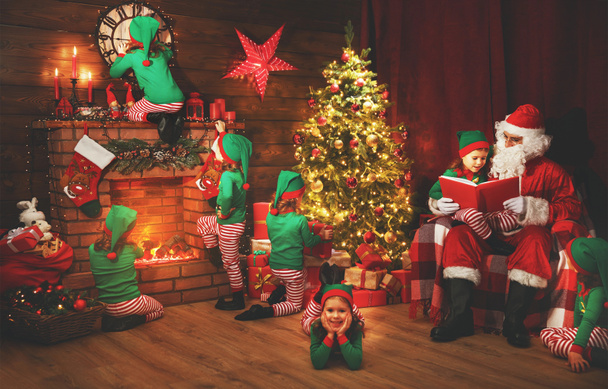 Santa Claus and little elves before Christmas in his hous - Photo, Image