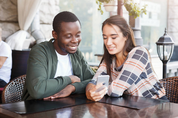 Nuori pari käyttää mobiili älypuhelimet kahvilassa
 - Valokuva, kuva