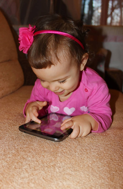 Uma criança pequena com um tablet. Foco seletivo
.  - Foto, Imagem