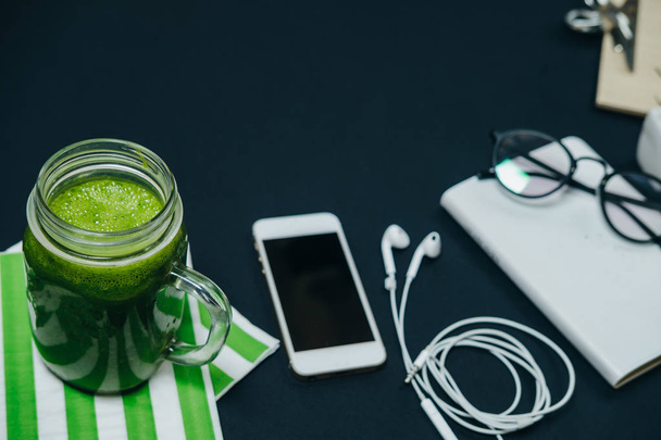 Freelancer workspace with phone, headphones notebook and a green - Фото, изображение