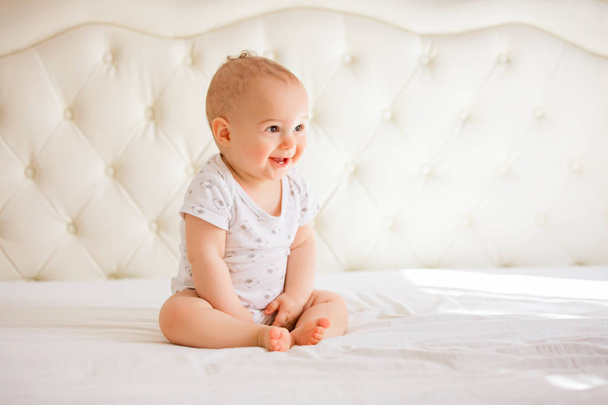 Adorable baby boy in white sunny bedroom - Фото, зображення