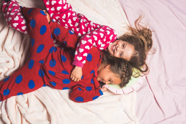 Dzieci w piżamie szczęśliwy uśmiech w łóżku, widok z góry - Zdjęcie, obraz