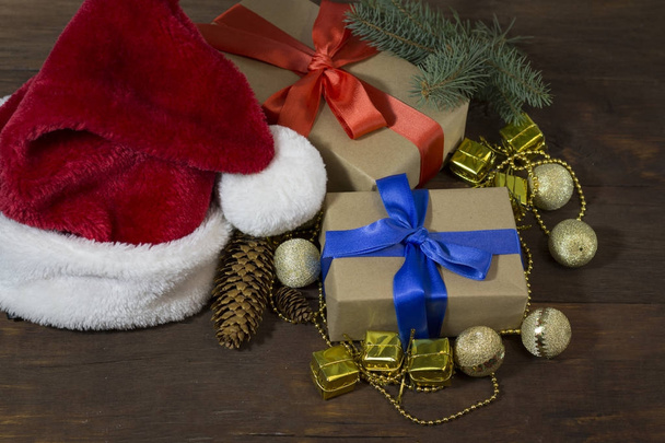 Санта Клауса капелюх, дві коробки подарунки, загорнуті в Крафт-папір і т - Фото, зображення