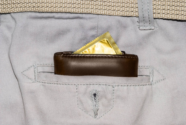 pénztárca egy zseb, a fehér farmert, egy arany óvszert - Fotó, kép
