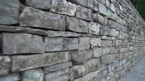 Walking near a stone wall. Handheld shot - Footage, Video