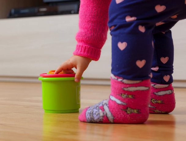 Toddler baby girl plays with colored cups, toy for cognitive development. - Photo, Image