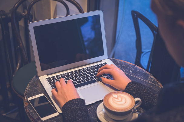Female hands on laptop keyboard in coffee shop - Zdjęcie, obraz