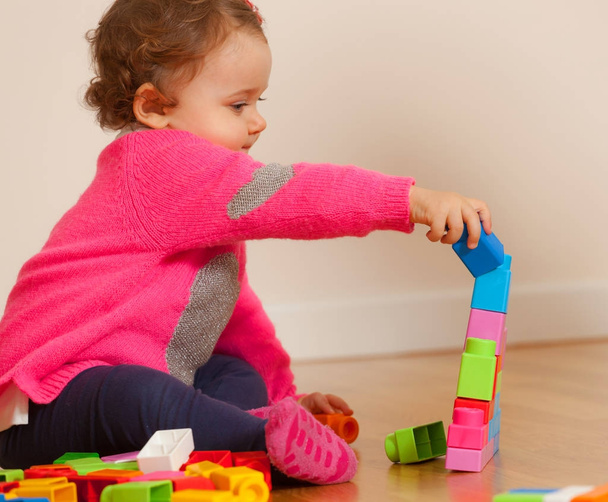 Tipegő baba lány játszik a puha gumi építőelemek. - Fotó, kép