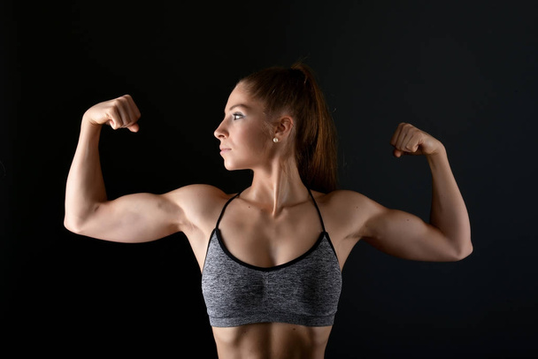 Brutal atlética mujer bombeando músculos con mancuernas
 - Foto, imagen