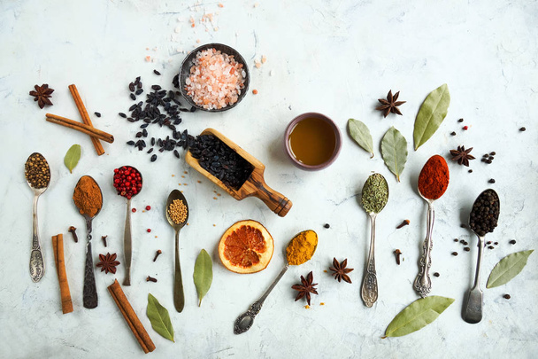 Various colorful indian spices and herbs in silver spoons on white background - Φωτογραφία, εικόνα