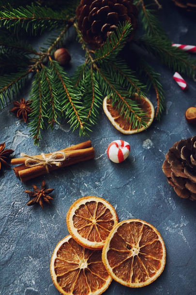 Cozy christmas background with dried oranges, fir tree, warm mittens, cinnamon and cones - Фото, зображення