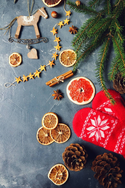 Cozy christmas background with dried oranges, fir tree, warm mittens, cinnamon and cones - Valokuva, kuva