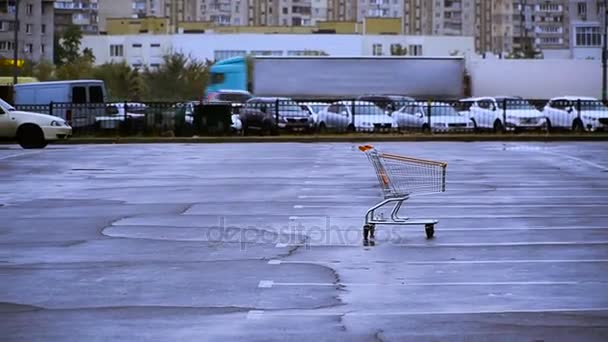 A shopping cart. The shopping trolley is in the parking lot - Felvétel, videó