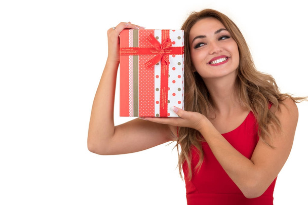 Muotokuva rento nuori onnellinen hymyilevä nainen pitää punainen lahjapaketti. Eristetty studio tausta naisten malli
. - Valokuva, kuva