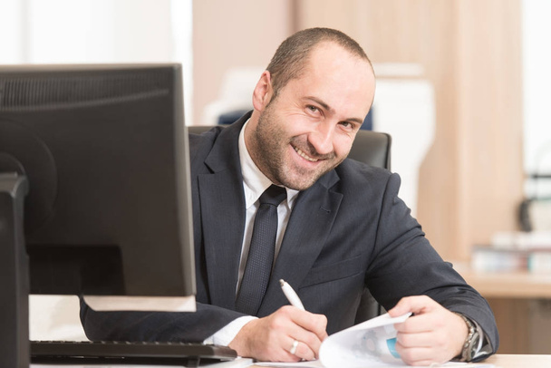 Businessman Sitting At Office Desk Signing A Contract - Photo, image