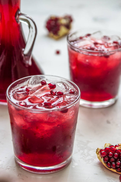 Pomegranat juice with ice and fruit slices - Фото, изображение