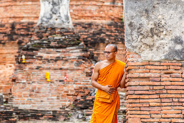 Monk stojící a podívat se na pohled před socha Buddhy na starého chrámu, Ayutthaya Province, Thajsko - Fotografie, Obrázek