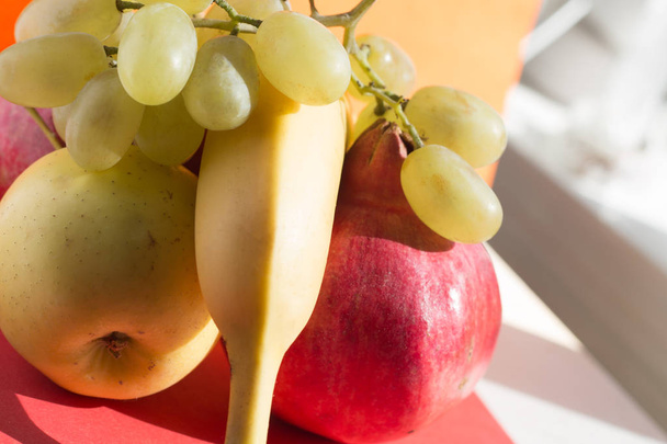 FRUIT PLATTER close-up: golden apple, banana, pomegranate and grapes - Photo, image