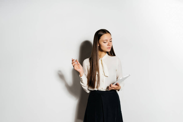 girl in white business shirt making notes in notebook - 写真・画像