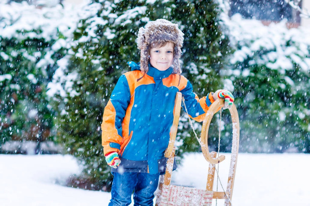 Petit garçon jouissant d'une promenade en traîneau en hiver
 - Photo, image