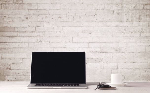Business laptop with white brick wall - 写真・画像
