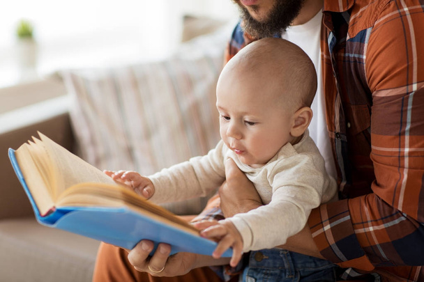 happy father and little baby boy with book at home - Fotó, kép