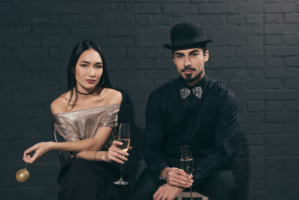 stylish multicultural couple with glasses of champagne - Zdjęcie, obraz