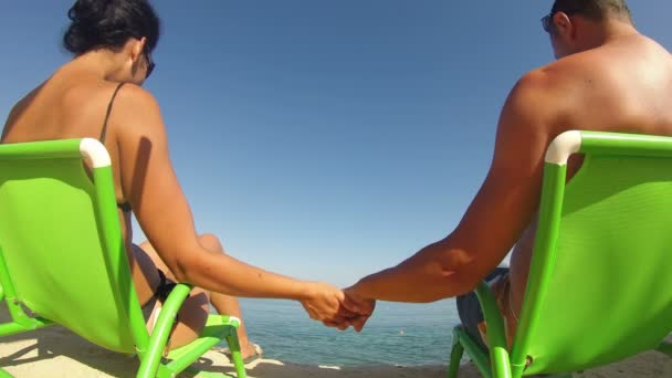 Couple sitting on beach and having romantic touches - Felvétel, videó