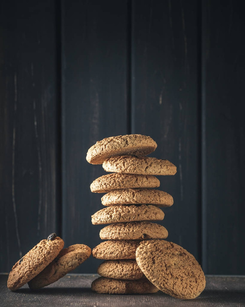 Stack of oat cookies over dark wood - Foto, Imagen