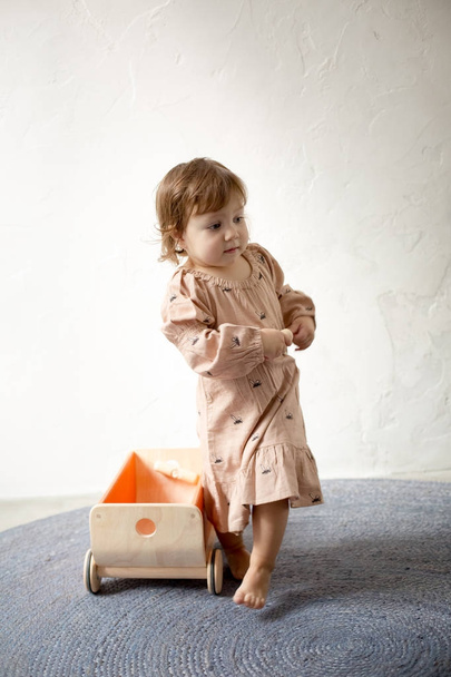 Girl playing with trolley, isolated on gray background - Photo, Image