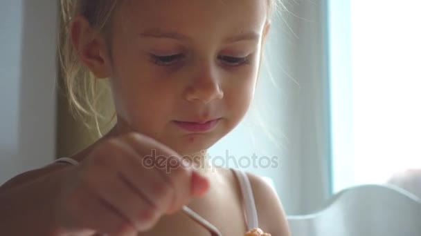 Πορτρέτο του ένα μικρό κορίτσι που τρώει μια σούπα. Ένα λευκό παιδί τρώει σούπα λαχανικών. 4 k βίντεο - Πλάνα, βίντεο