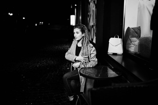 Κορίτσι με dreadlocks περπατώντας τη νύχτα δρόμο της πόλης. - Φωτογραφία, εικόνα