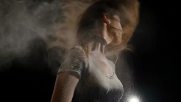 une jeune femme flotte ses cheveux dans une farine
 - Séquence, vidéo