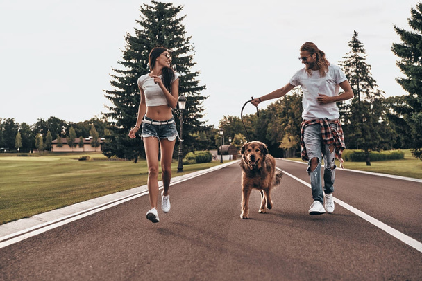 couple in love with big dog running - Фото, изображение