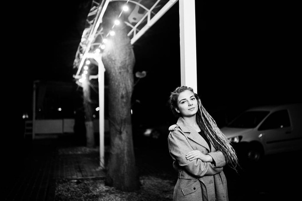Girl with dreadlocks walking at night street of city. - Valokuva, kuva