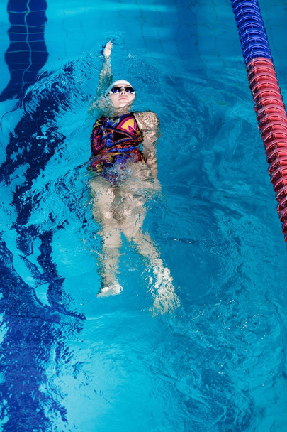 woman swimming with swimming hat in swimming pool - Foto, Imagem
