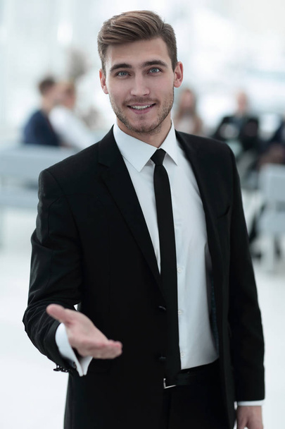 confident young businessman holds out his hand for greeting - Фото, зображення