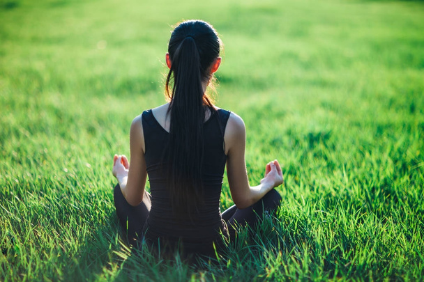 Young woman meditating on grass - Fotó, kép