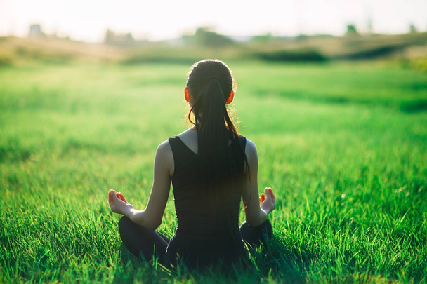 Young woman meditating on grass - Foto, imagen