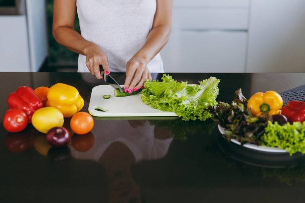 Młoda kobieta kawałki warzyw w kuchni z nożem. Zdrowa żywność - Sałatka warzywna. Pojęcie diety. Zdrowy styl życia. Gotowanie w domu. Przygotować jedzenie zbliżenie - Zdjęcie, obraz