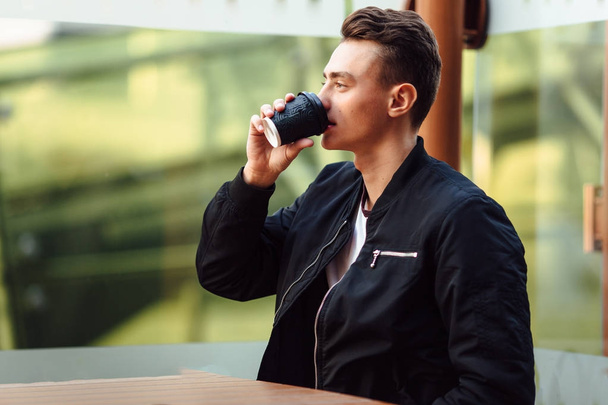 Man with cup of coffee talk on his phone - Φωτογραφία, εικόνα
