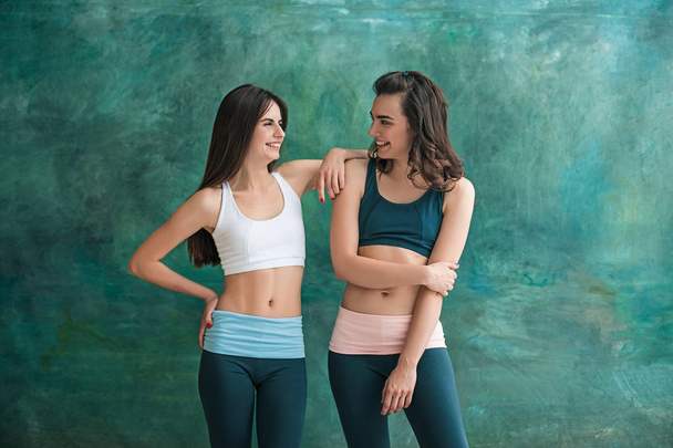 Two young sporty women posing at gym. - Foto, Bild