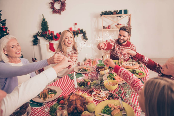 Cheerful relatives sit and celebrate with sparkles up gathered t - Photo, image
