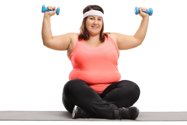 Overweight woman exercising with small dumbbells - Φωτογραφία, εικόνα