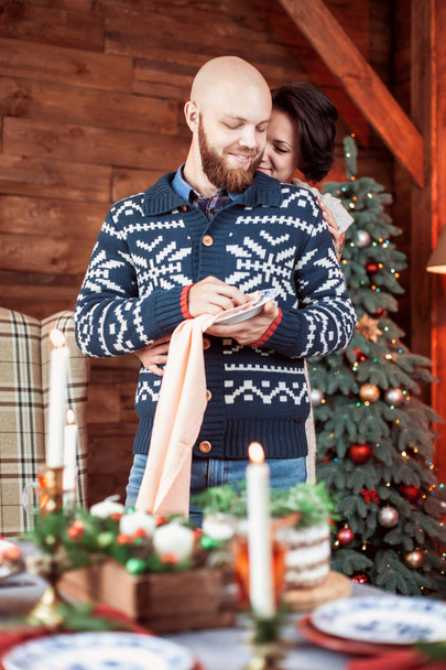Beautiful young couple with Christmas tree - 写真・画像