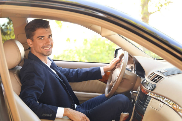 Jonge zakenman in een auto - Foto, afbeelding